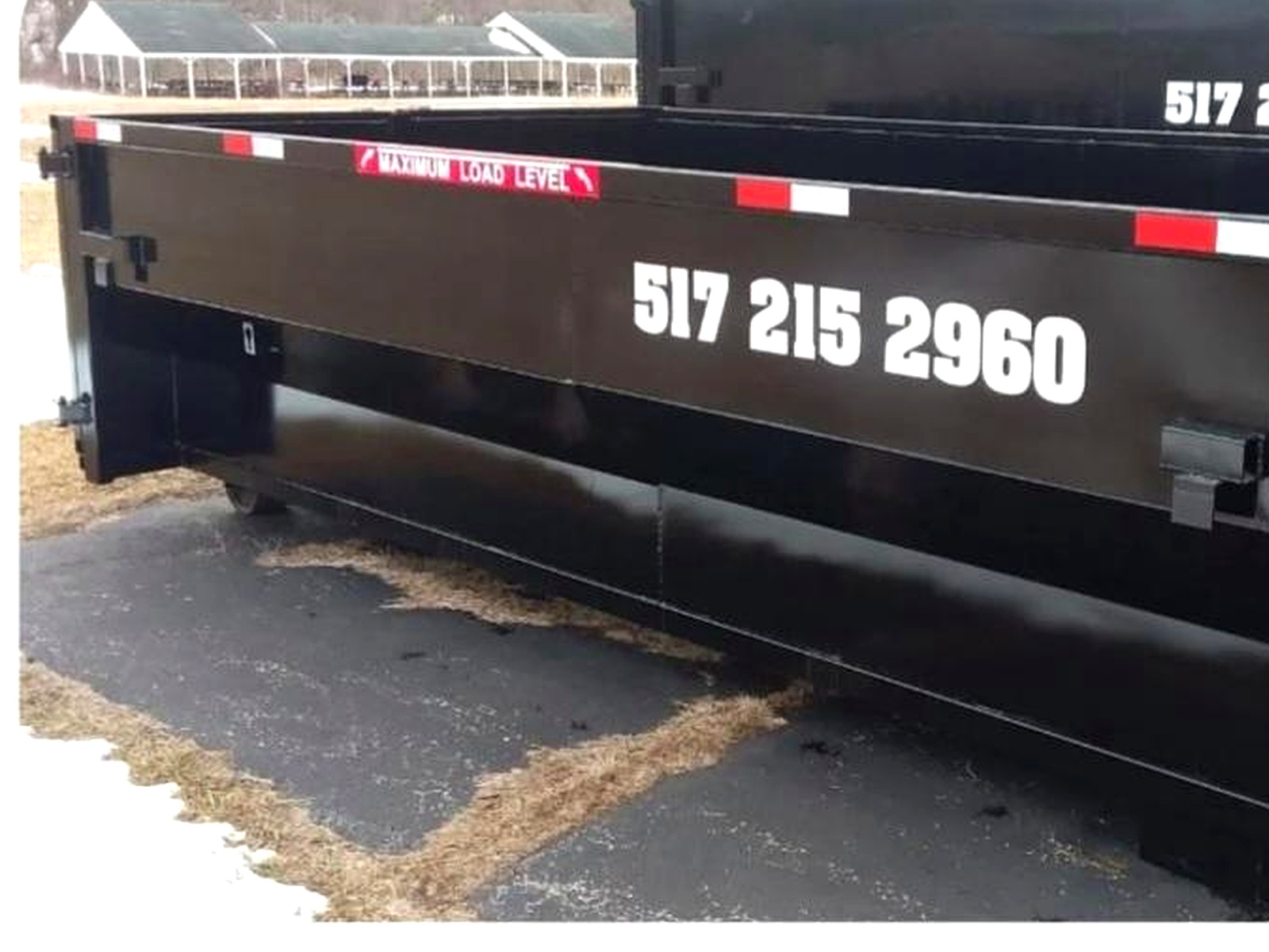 17 Yard Dumpster — black Skeels dumpster with 517 215 2960 on the side